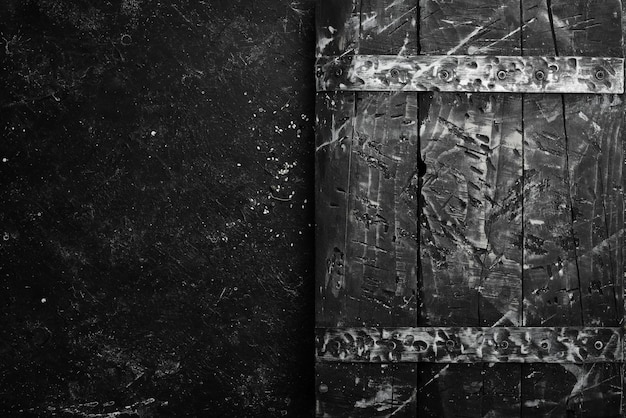 Photo black old kitchen board. top view. free space for your text. on a black stone background.