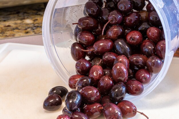 Black olives in pot over the sink for recipe preparation.