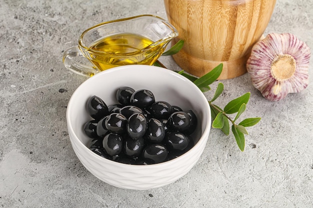 Photo black olives with oil and branch