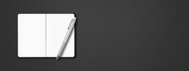 Black open lined notebook with a pen isolated on dark table