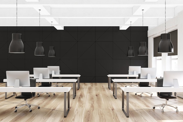 Black open space office environment with a concrete floor, tall windows, and two rows of computer tables. 3d rendering mock up