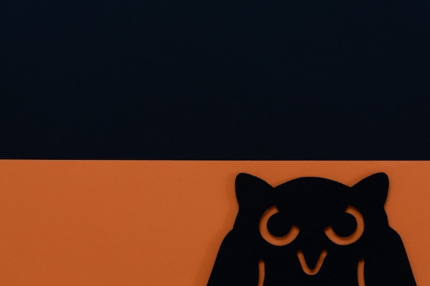 Black and orange Halloween background with owl silhouette