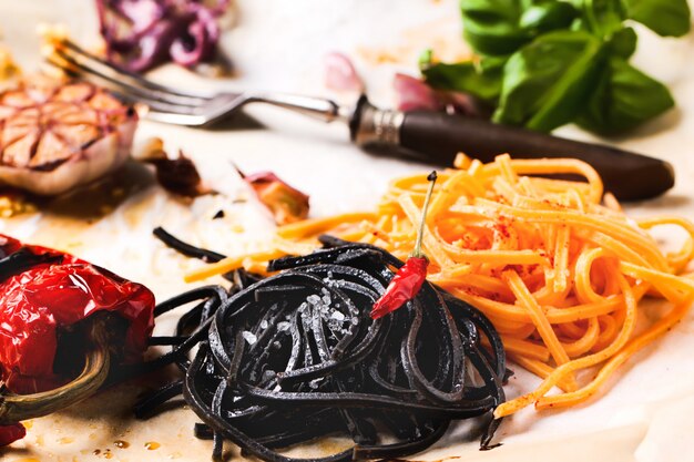 Foto spaghetti neri e arancioni con verdure grigliate