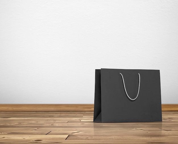 Black paper bag in room white walls and wooden floor