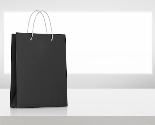 Black paper bag on white wooden table