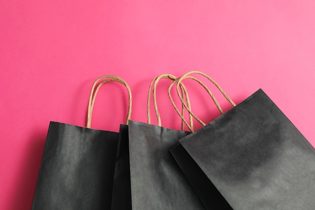 Black paper bags on pink