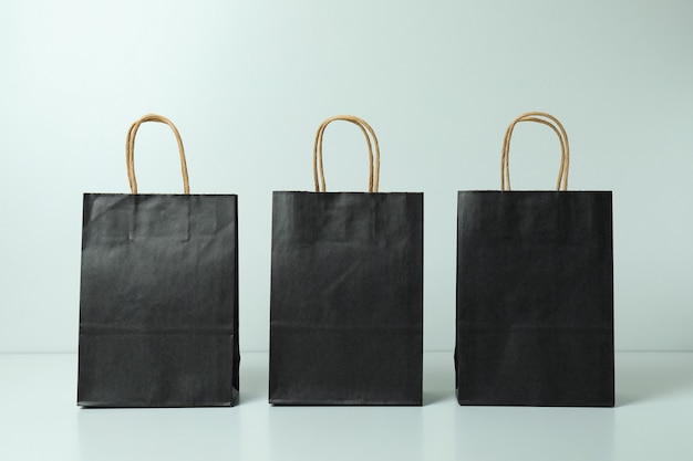 Black paper bags on white background, space for text