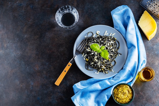 Black pasta with cuttlefish ink on a gray plate