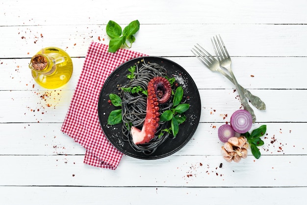 Black pasta with octopus tentacles Seafood on a stone plate In the old background Top view Free copy space