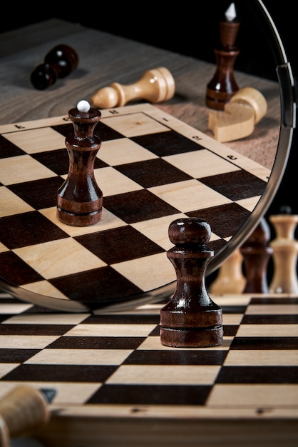 The black pawn looks in the mirror and sees the reflection of the queen, the concept of strategy, planning and decision-making, the concept of a leader for success