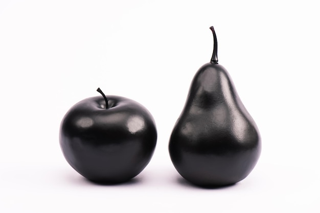 Black pear and apple on white with copy space