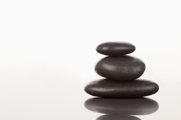 Photo black pebbles stack on a mirror