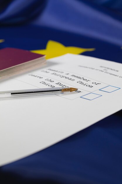 Foto penna nera su una scheda elettorale per il referendum dell'ue. passaporto in background. avvicinamento