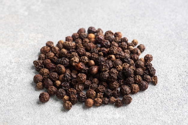 Black pepper peas on a gray concrete background, copy space.
