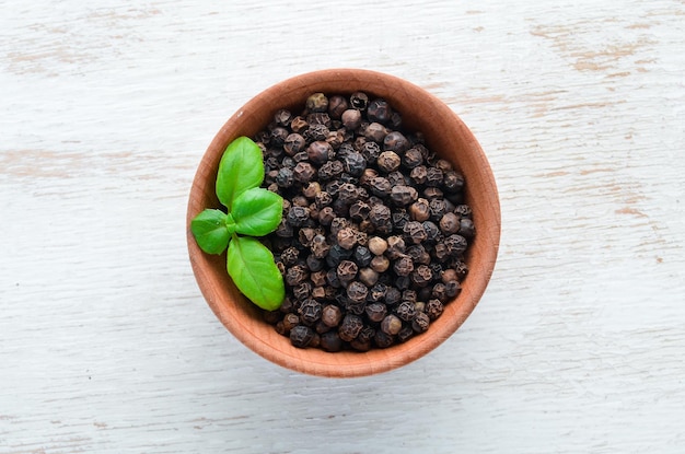 Black pepper peas. Spices Top view. On the old background.