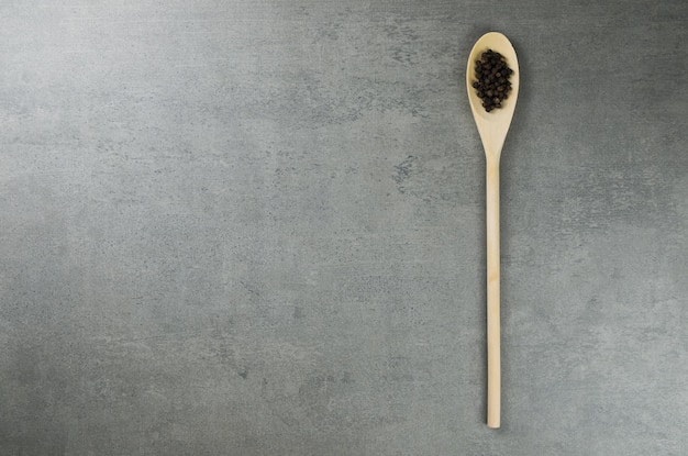 Black pepper spice in wooden spoon