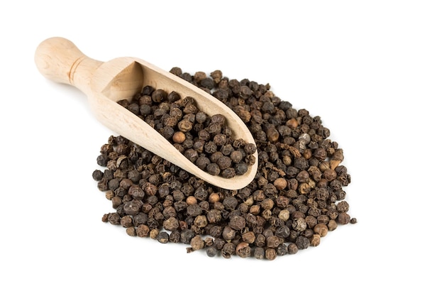 Black pepper in a spoon for spices isolated on a white background