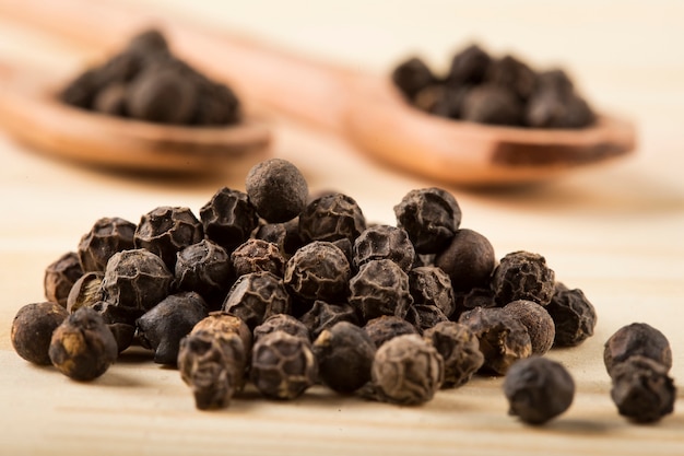 Black pepper on a wooden background