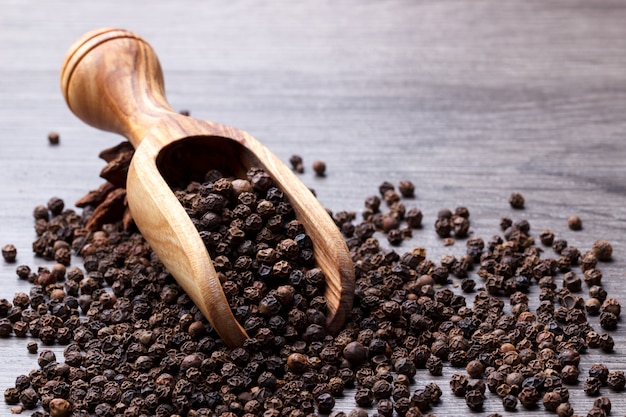 Black pepper in wooden scoop 