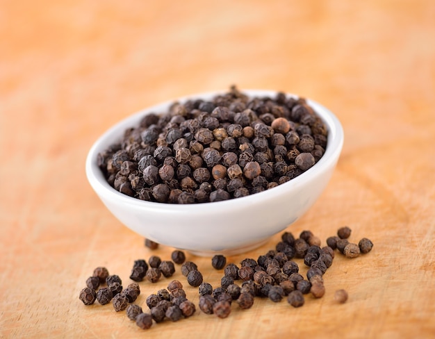 Black peppercorn on wooden table