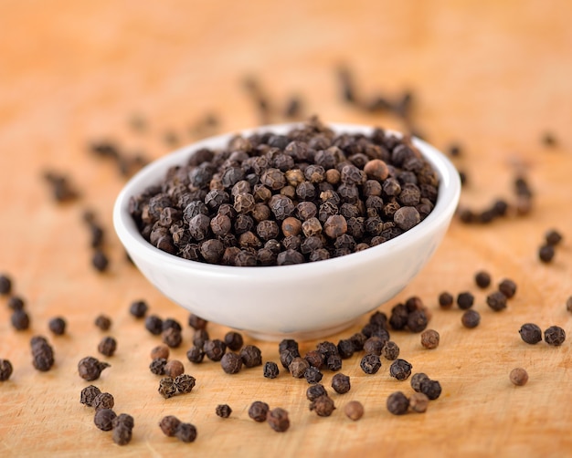 Black peppercorn on wooden table