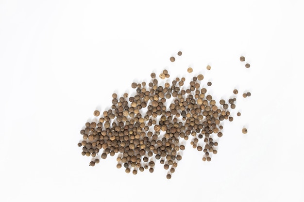 Black peppercorns on white table, flat lay