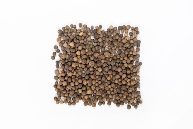 Black peppercorns on white table, flat lay