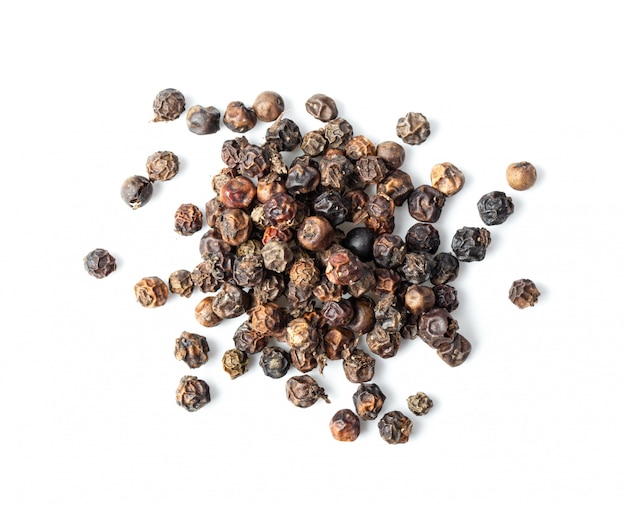 Black Peppercorns on white table.