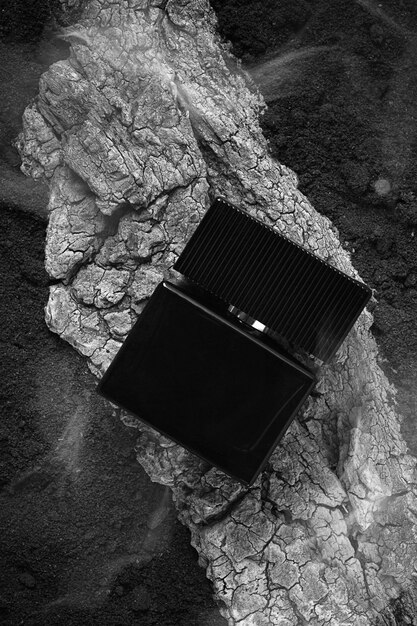 Black perfume bottle mockup on a wooden board top view no people vertical selective focus