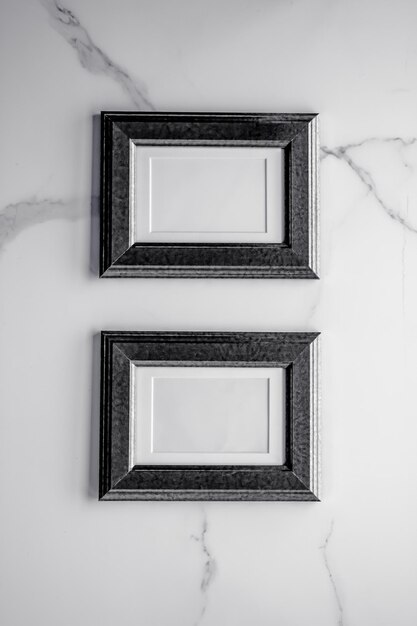 Black photo frame on marble flatlay