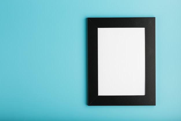 Black photo frame with empty space on a blue background.