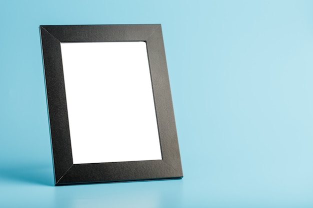 Black photo frame with empty space on a blue background.