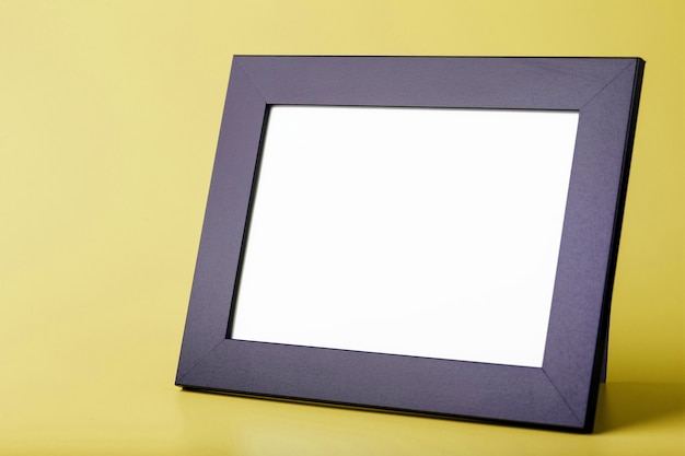 Black photo frame on a yellow surface