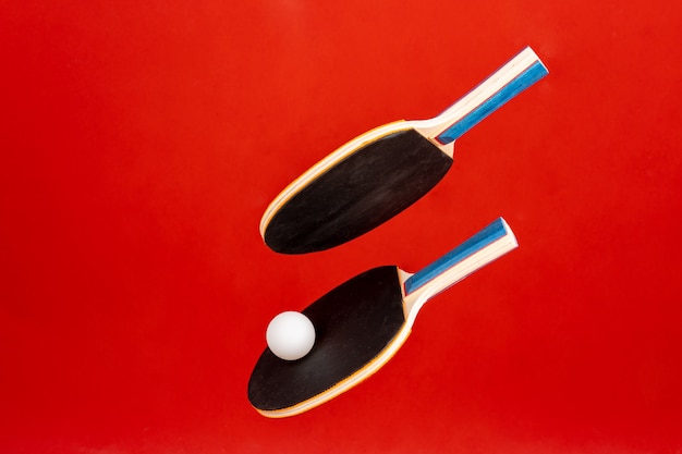 Black ping pong rackets on red background