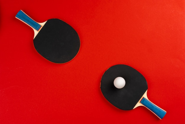 Foto racchette da ping-pong nere su fondo rosso