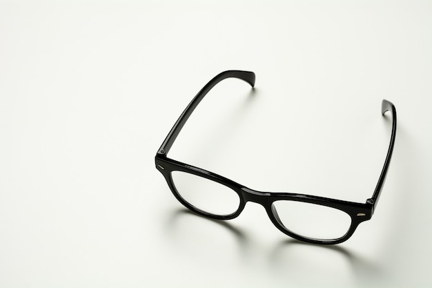 Black plastic glasses and a shadow on white background