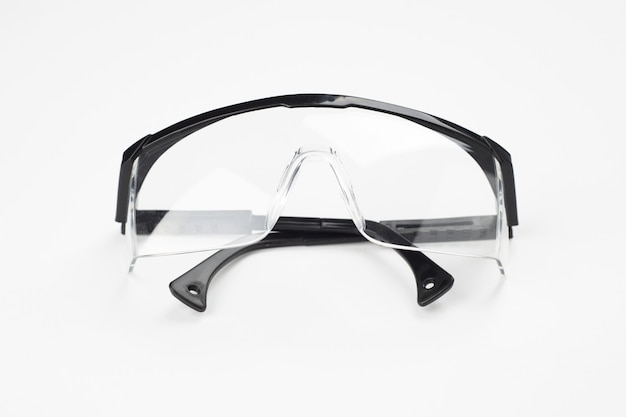 Photo black plastic protection glasses on white. protection workwear concept