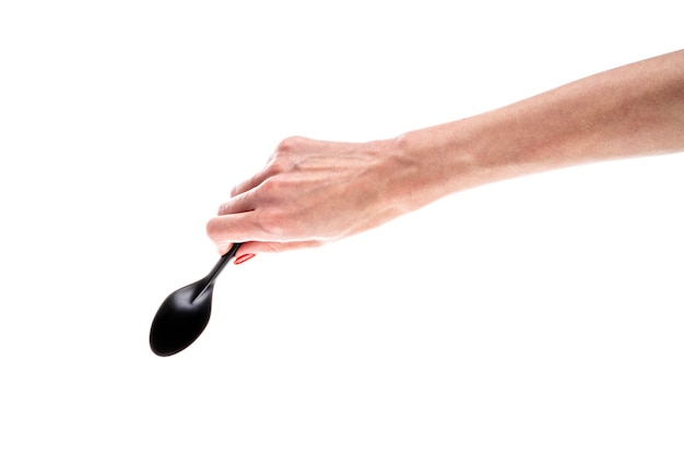 Black plastic spoon in female hand isolated on white background