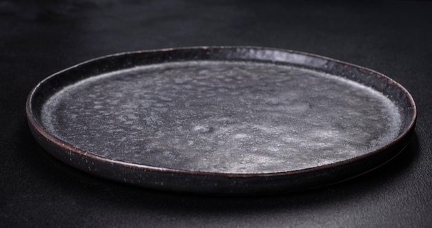 Black plate on a black background Flat lay top view copy space