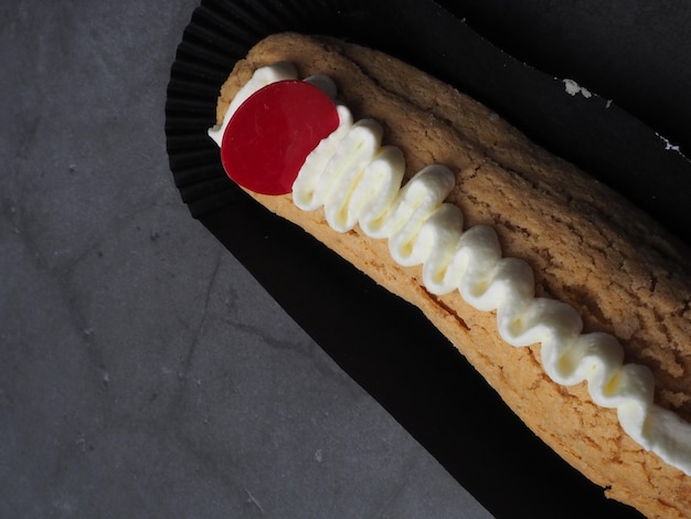 A black plate with a red cherry on top of it