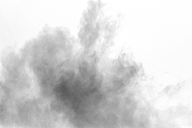 Black powder explosion against white background. Charcoal dust particles exhale in the air.