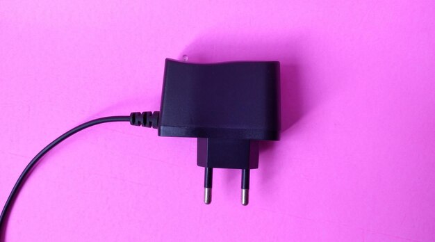 Photo black power plug on a pink background copy space for text