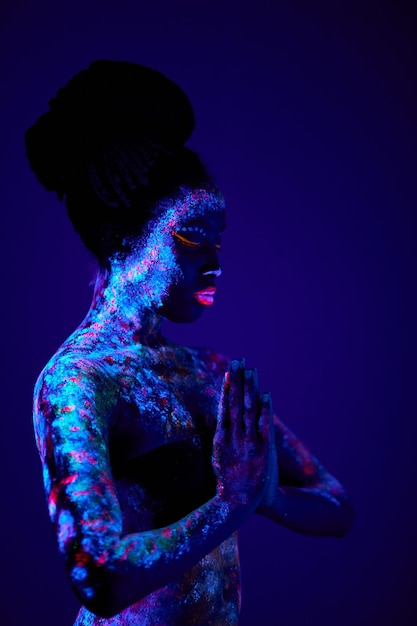 Фото Черная молящаяся женщина с красочными флуоресцентными отпечатками на коже красивая женская молитва