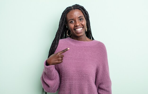 写真 誇りに思って、自信を持って幸せそうに見える黒人のきれいな女性、笑顔で自分を指さしている、またはナンバーワンのサインを作っている