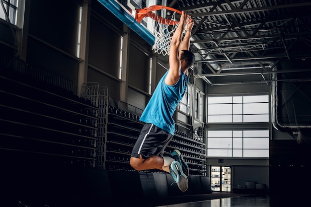 Foto giocatore di basket nero professionista nero in azione in un campo da basket.