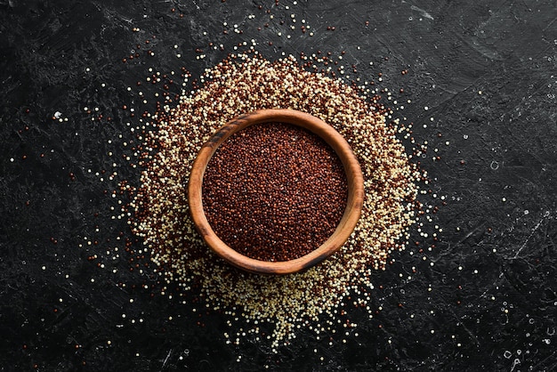 Black quinoa in a wooden bowl On a stone background Top view