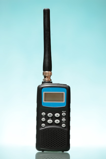 A black radio scanner over blue background