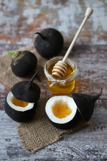 Black radish with honey on a wooden table