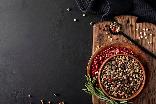 Black and red allspice in wooden bowls, top view