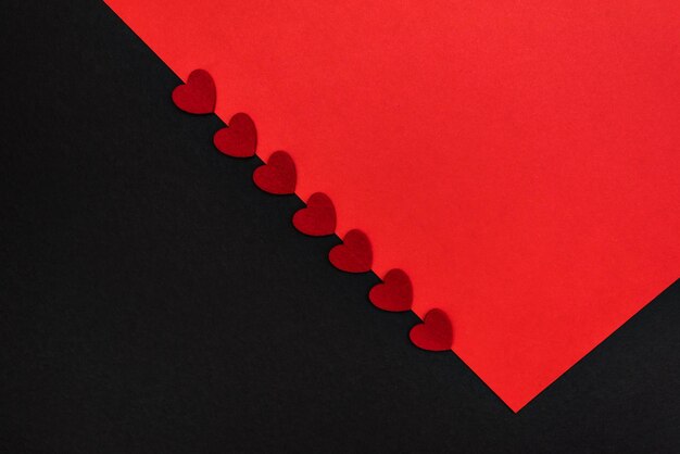 Black and red background, divided diagonally, decorated with red hearts